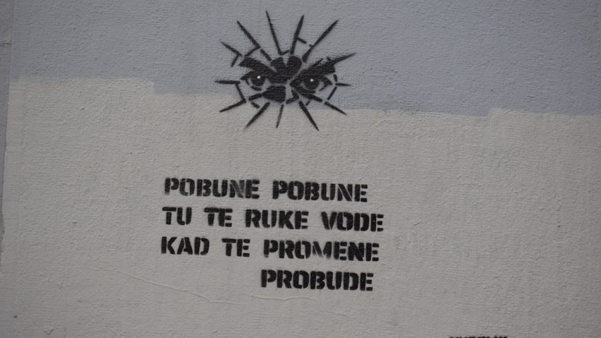 Graffiti with eyes and text on a wall
